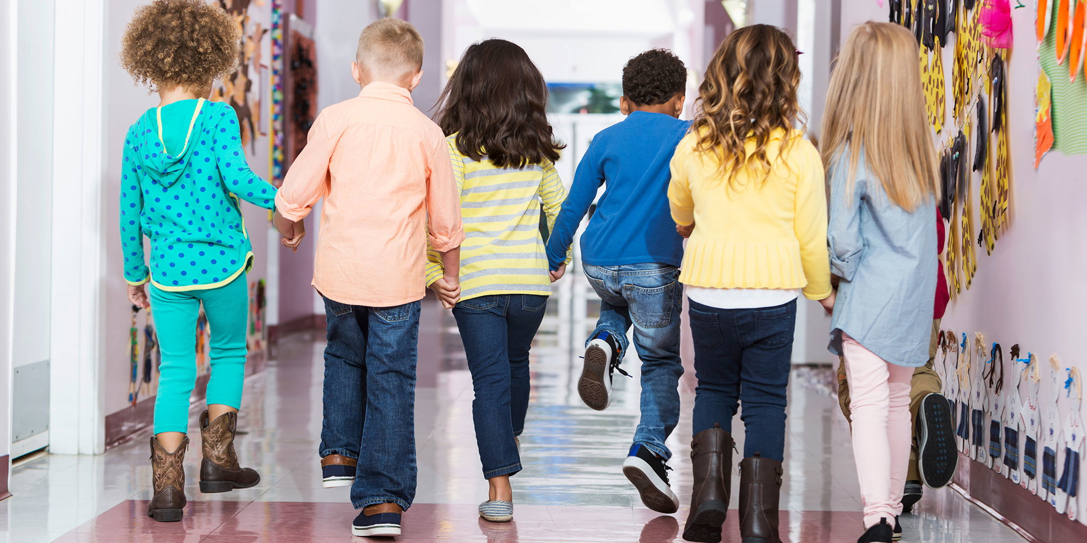 Kids holding hand walking down the hall